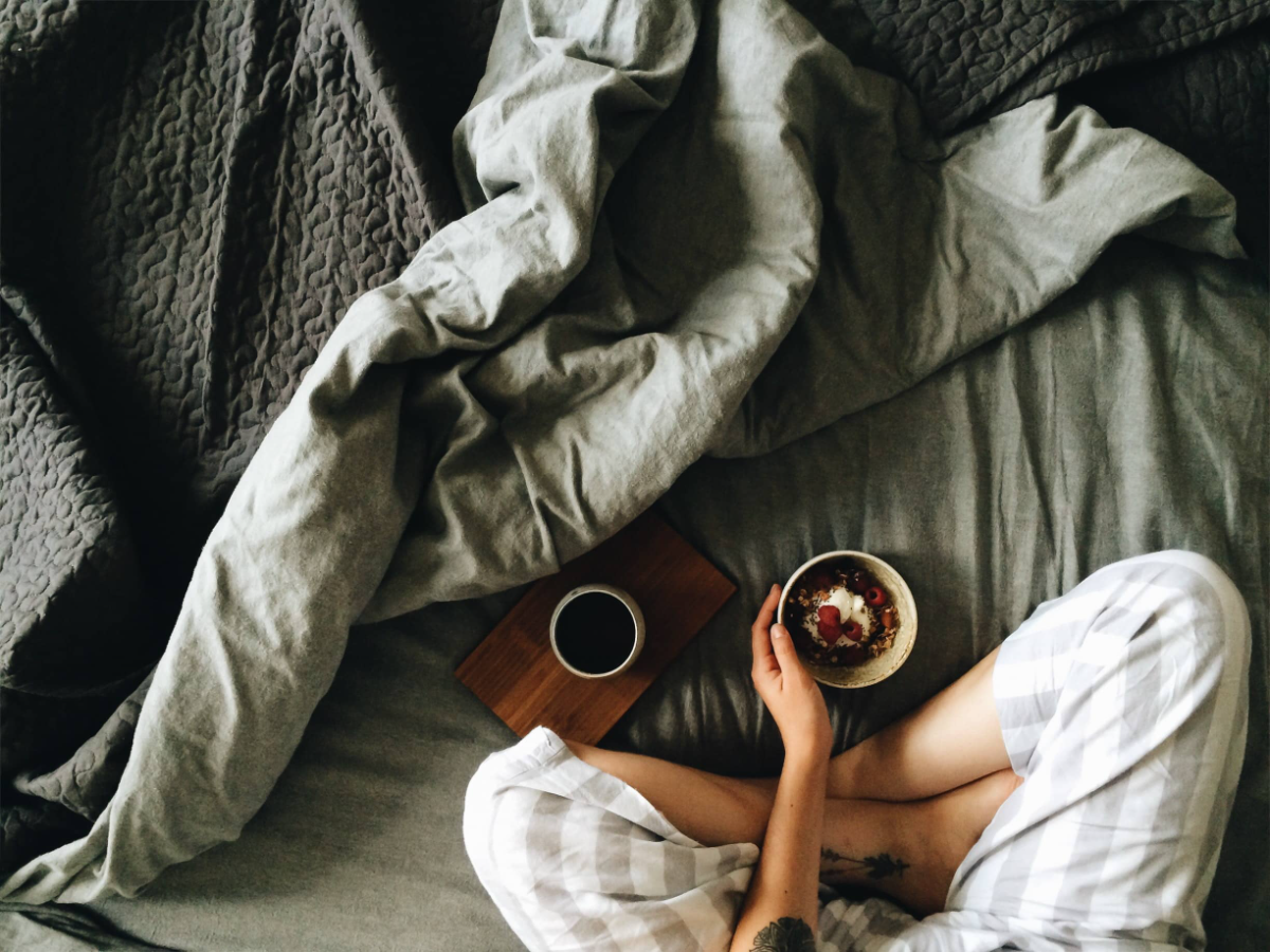guest in bed with cereal and cup of coffee on wooden board  Bed and breakfast software